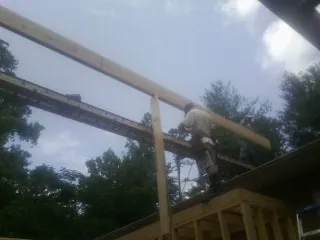 Carpenter setting a ridge beam over a new addition frame — Ice Dam Removal by Roofing Brothers in East Carbon