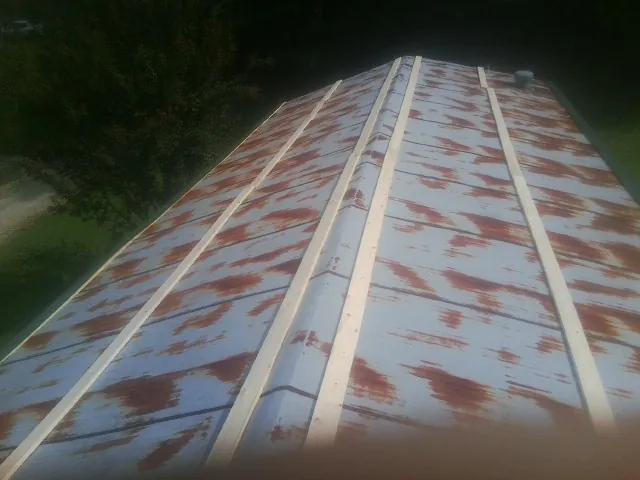 Rusted metal roof panels with new wood purlins before replacement — Storm Damage Roof Repair in East Carbon by Roofing Brothers