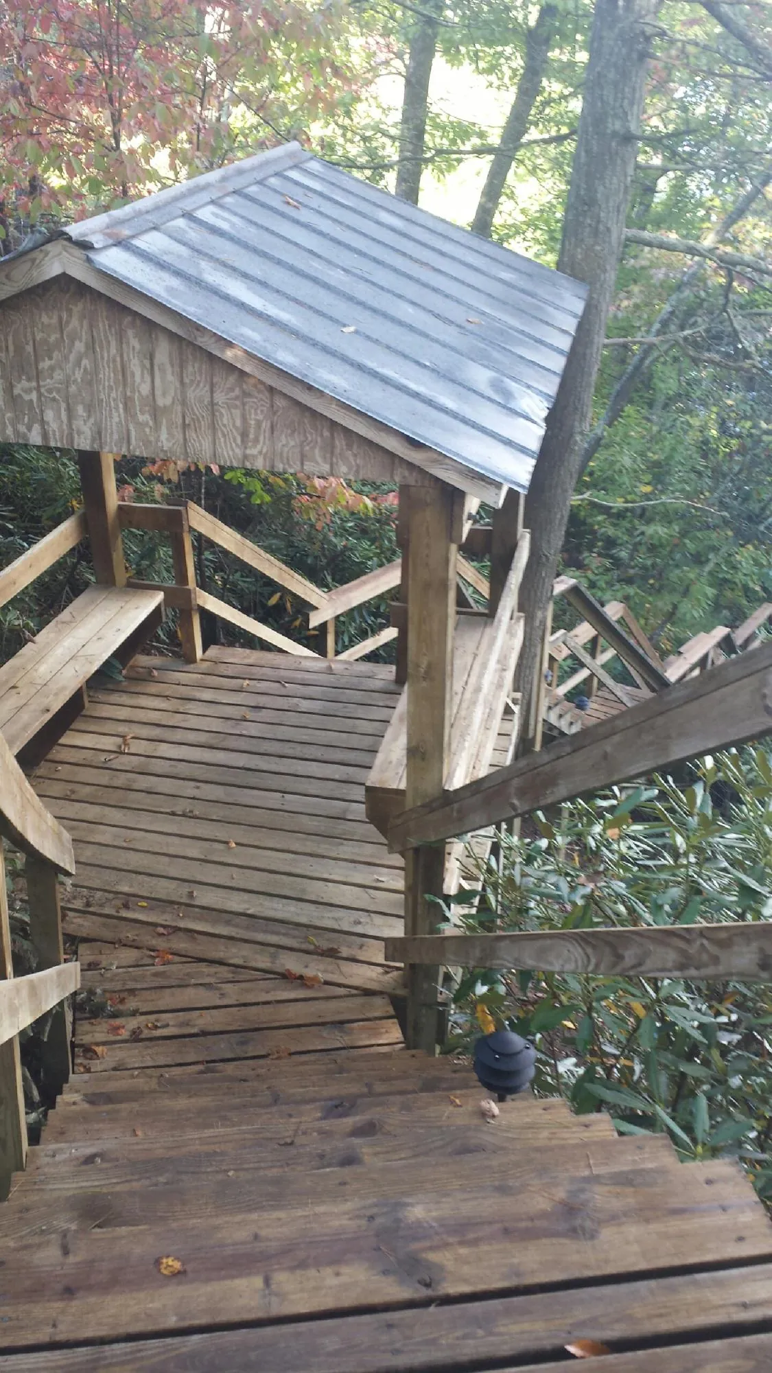 Metal roofed shelter over wooden steps on a wooded walkway — Skylight Repair & Installation work by our crew in East Carbon