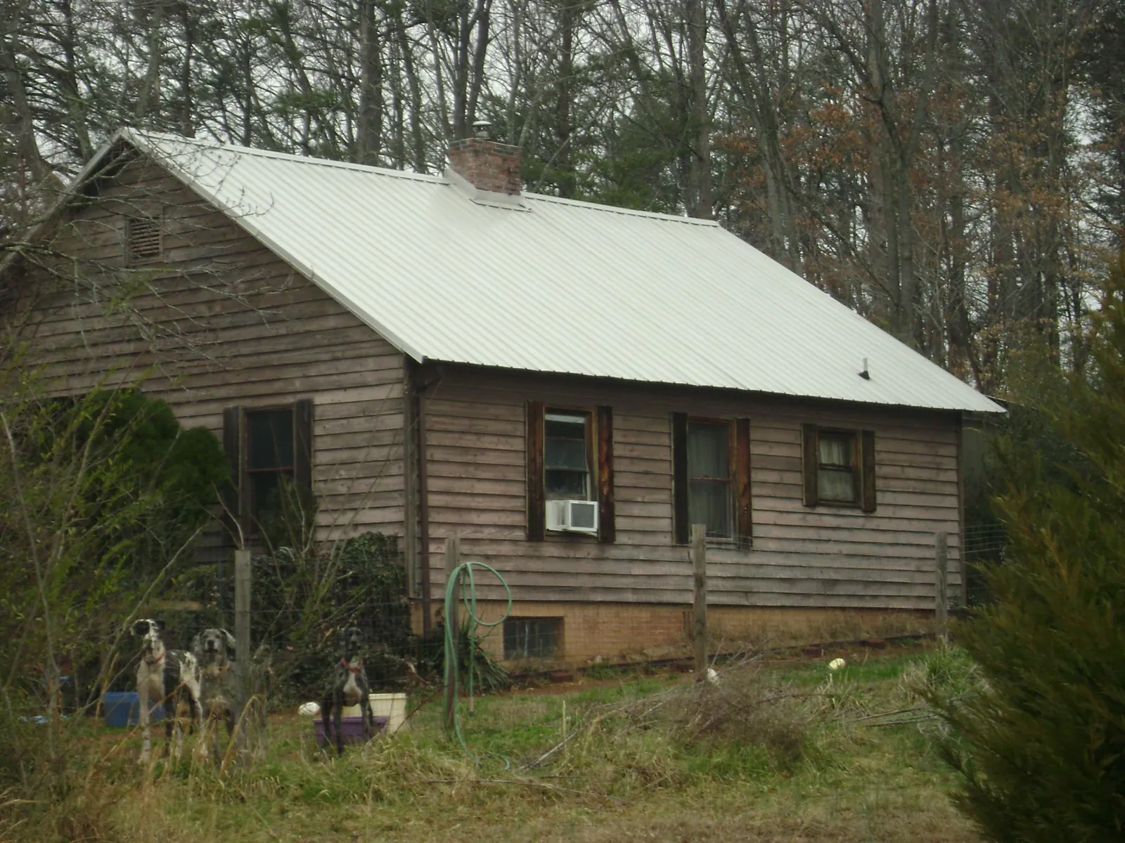 White metal roof on an old wood sided farmhouse, from a Metal Roof Installation job in East Carbon